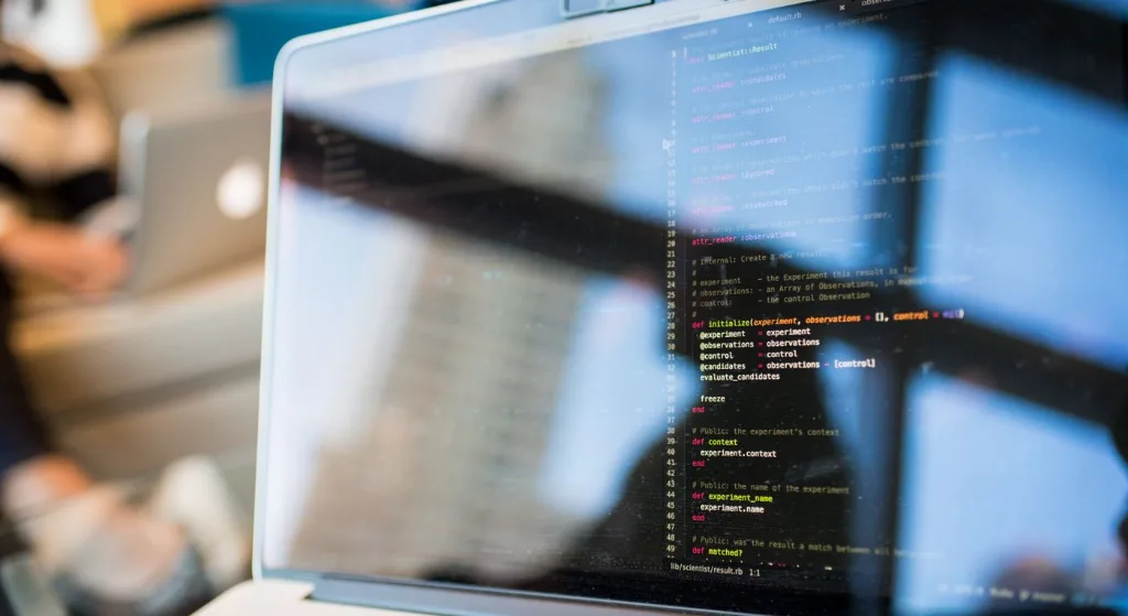 Laptop displaying code with reflection, perfect for tech and programming themes